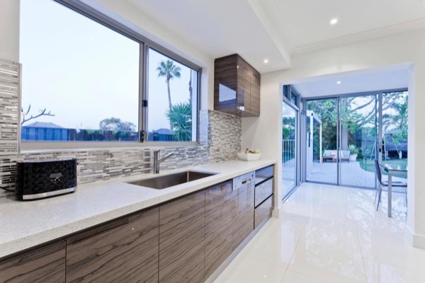 A clean modern kitchen with a garden view