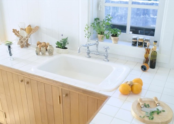 A tidy white sink by a sunny window
